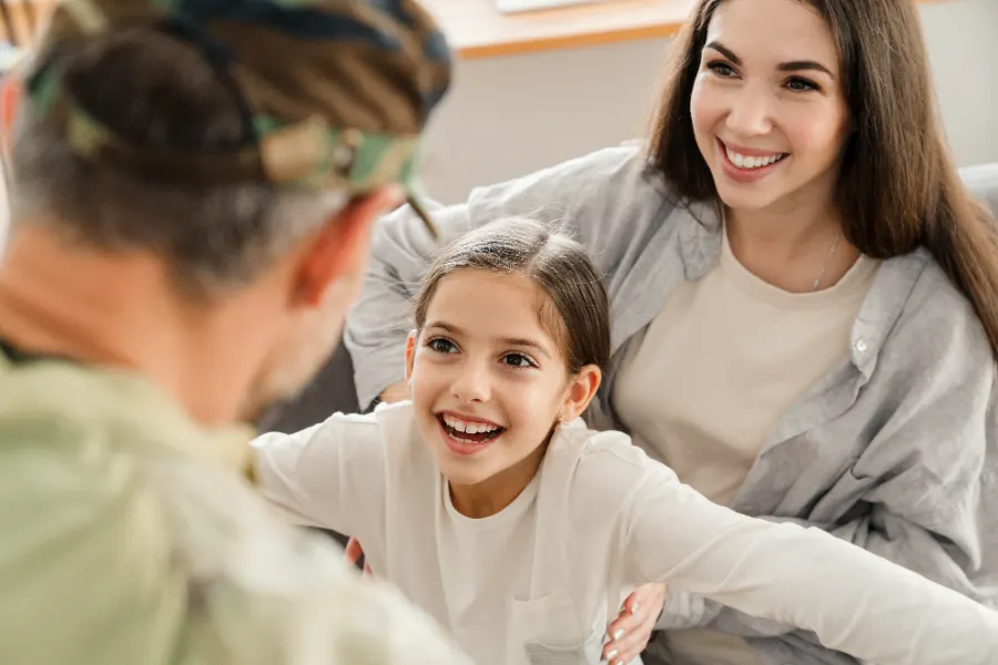 A veteran reunited with his smiling daughter and partner at home